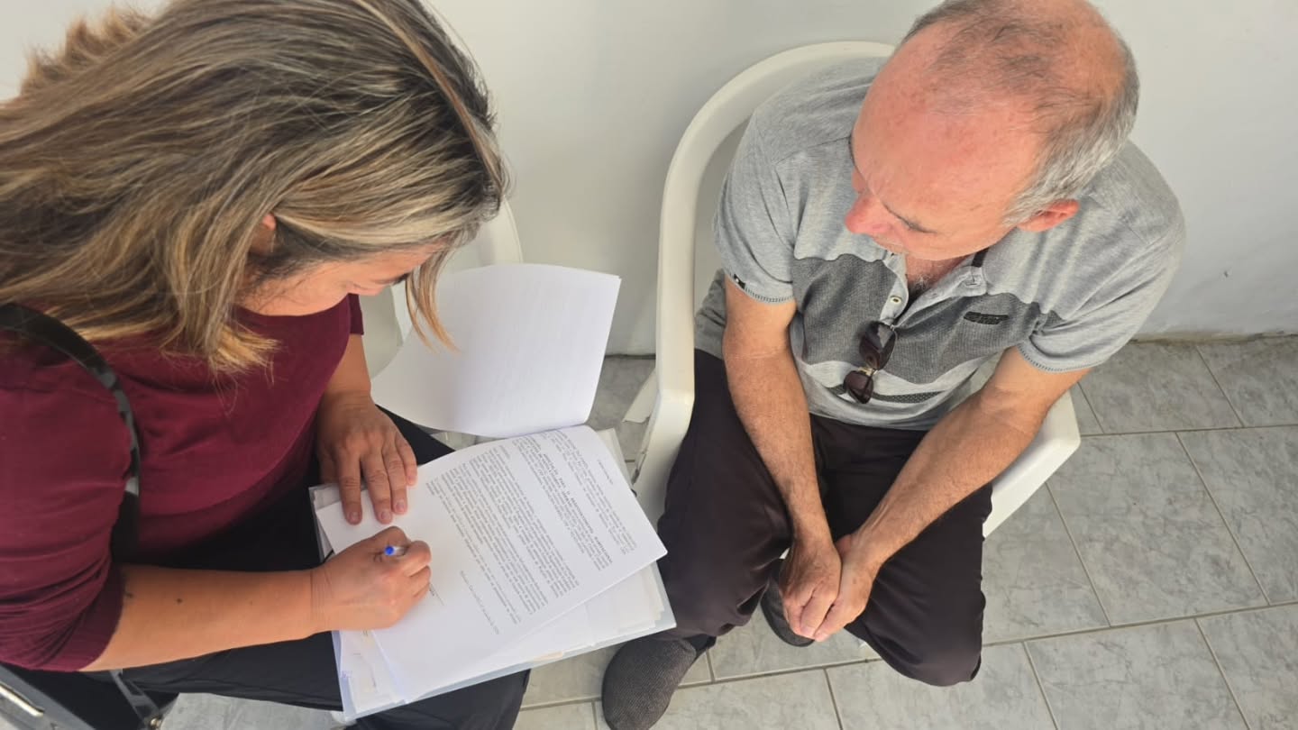 Atendente preenchendo documentos com morador