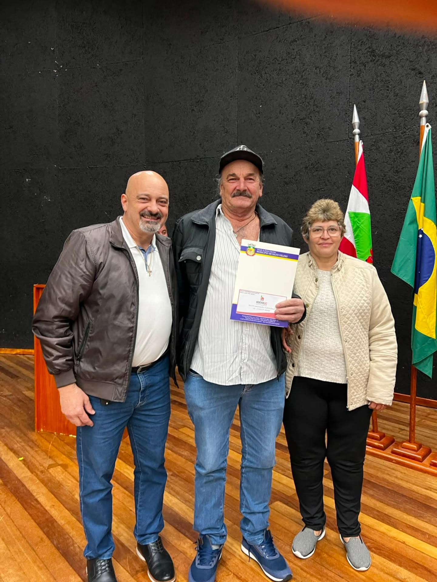 Entrega de título - casal (senhora de bege)
