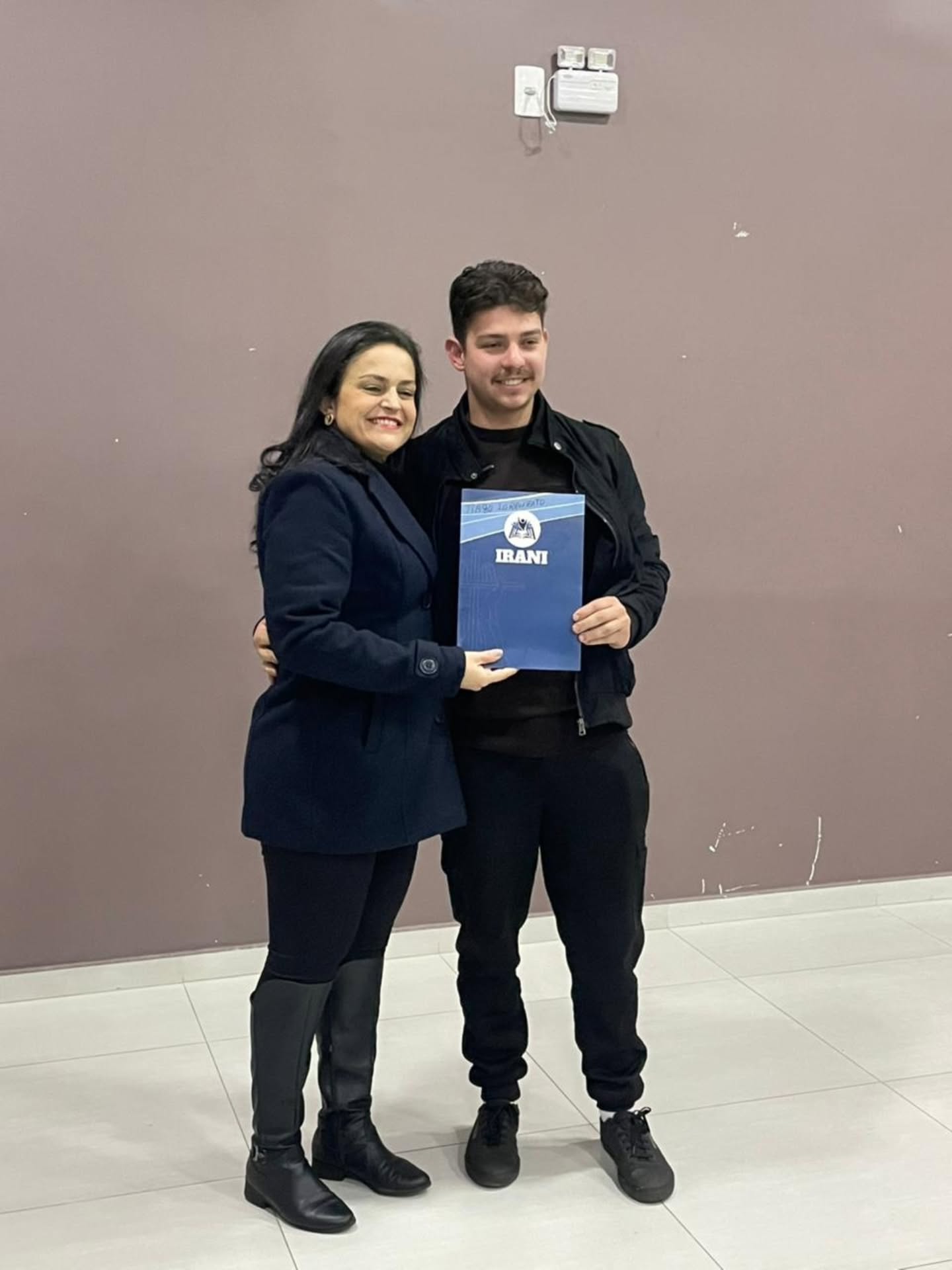 Entrega de título - jovem de bigode