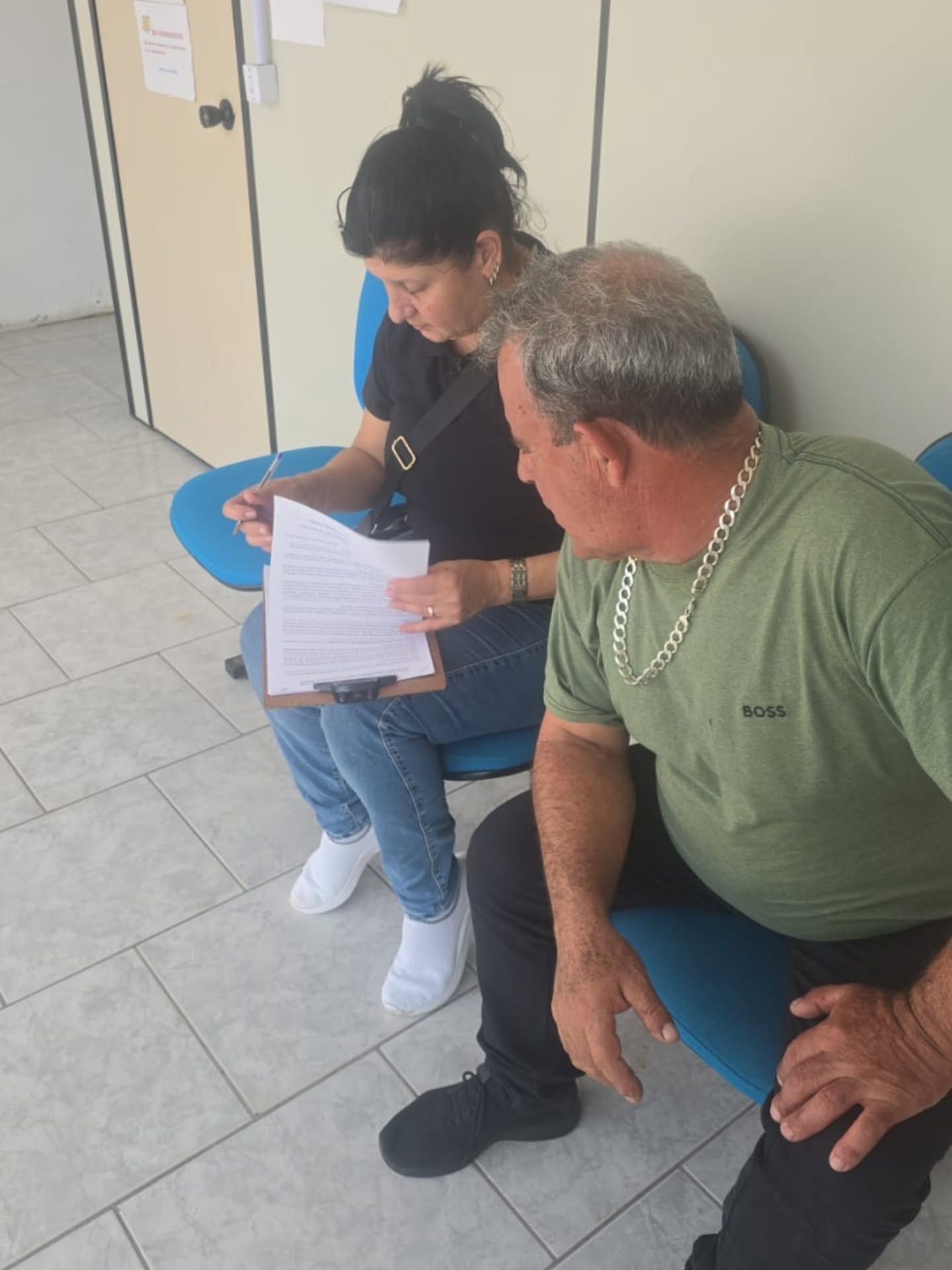 Moradora assinando na prancheta